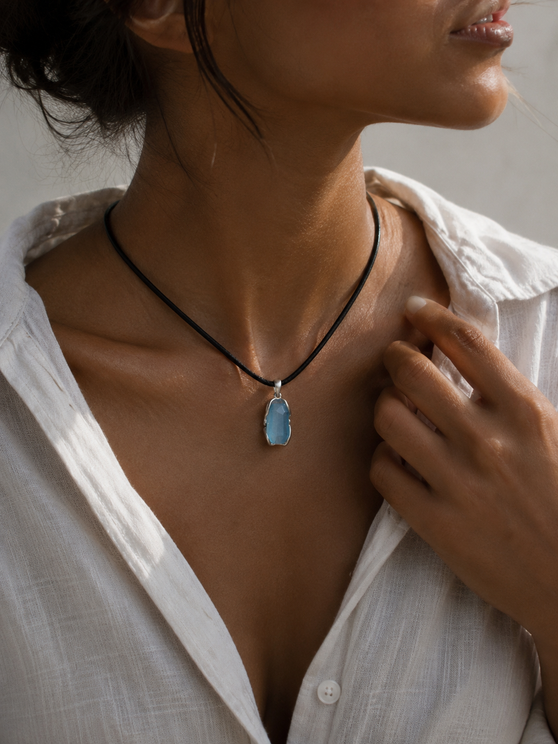 Woman wearing the VeilBond Through the Tide aquamarine necklace