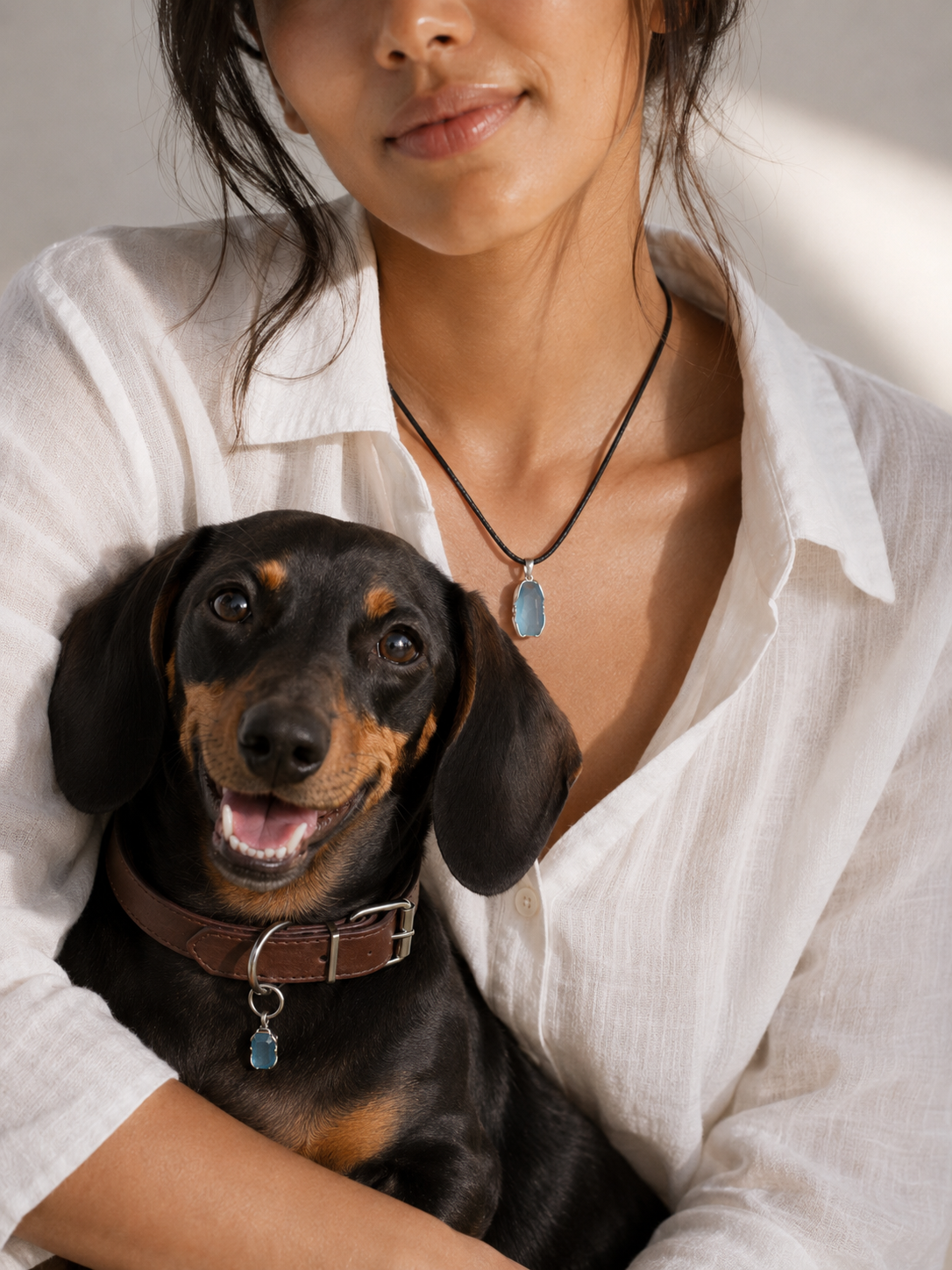 Woman and dog wearing matching VeilBond aquamarine pieces